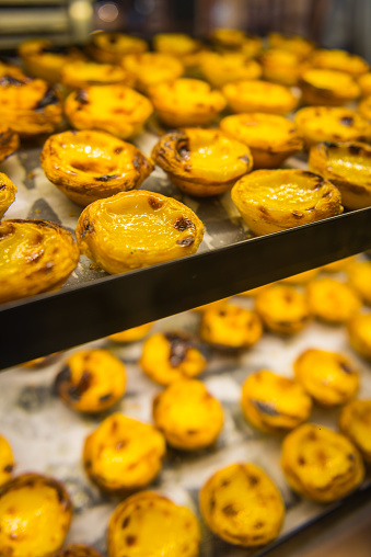 Traditional pasteis de nata custard tarts for sale in a bakery window in the Belem district of Lisbon, Portugal.