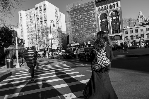 Christopher street, Greenwich Village, Manhattan, New York, USA - March, 2024. Woman walking across a crosswalk.