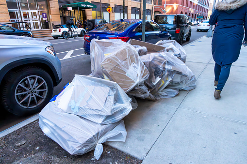 Christopher street, Greenwich Village, Manhattan, New York, USA - March, 2024. Garbage bags piled up beside the road waiting for collection.