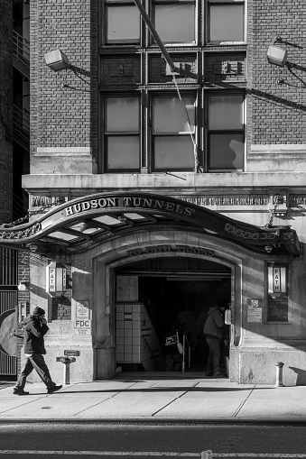 Christopher street, Greenwich Village, Manhattan, New York, USA - March, 2024. Man walking in front of the Hudson Tunnels entrance.