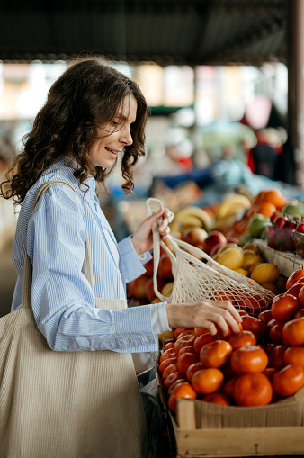Woman is shopping for organic oranges at the farmer's market