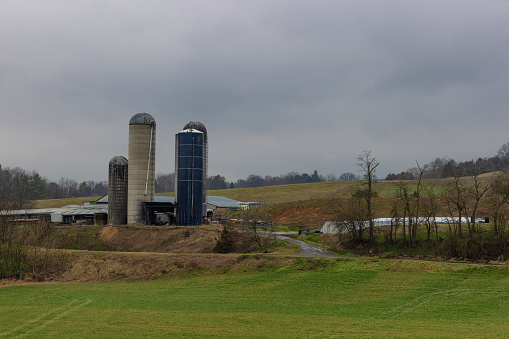 Agricultural landscape with barn and silos on a hillside under cloudy skies in rural Virginia, USA