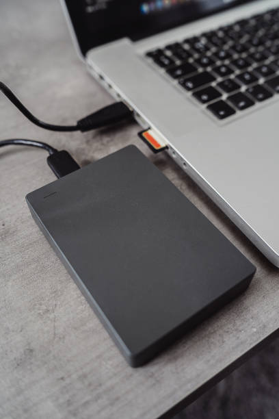 istock External hard disk drive connected to a modern laptop via USB 2135719224