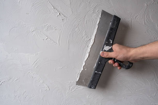 istock Applying decorative putty. White abstract texture of surface covered with putty 2135728453
