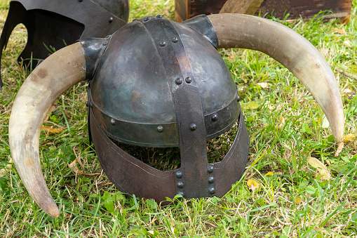 Medieval Viking wrought iron helmet with horns placed on the ground