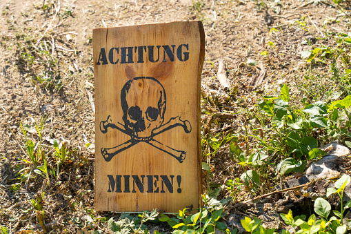 World War II minefield warning wooden sign with German inscription and skull
