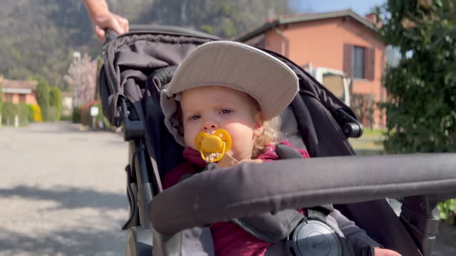 Baby toddler being pushed in stroller on sunny day