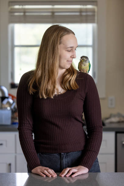 istock Green Cheek Conure and Young Woman 2135765908