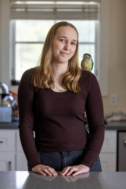 istock Green Cheek Conure and Young Woman 2135765910
