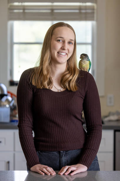 istock Green Cheek Conure and Young Woman 2135765911