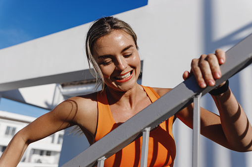 Happy Fitness Woman Running by a Staircase During Her Intense Workout.