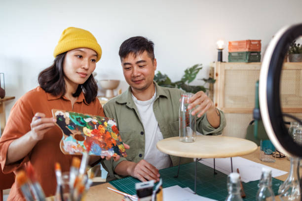 istock Young hipster couple vlogging about glass art from their small home based workshop 2135784420