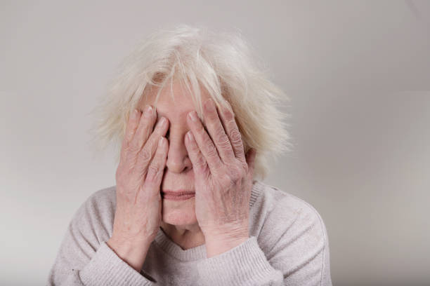 Senior woman covering face with her hands studio shoot