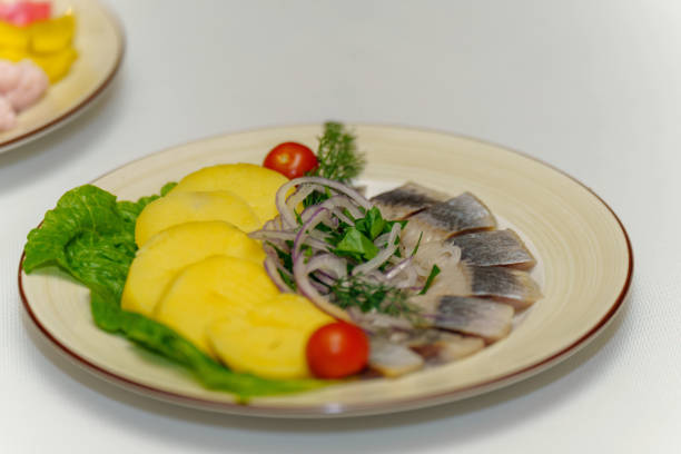 istock Dish on the table herring fillet with potatoes and fresh vegetables 2135797717
