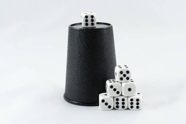 istock White gambling dicaes and a black raffle cup, isolated on white. 2135806118