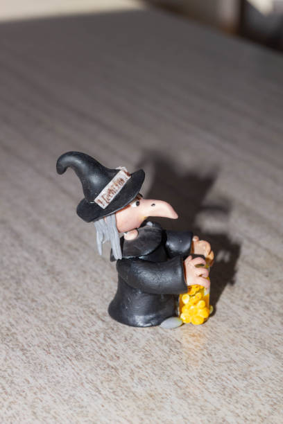 Halloween witch figurine with candles and magic potion in glass bottle stock photo