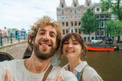 Selfie of cheerful heterosexual couple in Amsterdam in summer