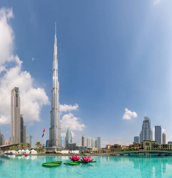 Dubai, United Arab Emirates - November 7, 2023: A picture of the Burj Khalifa towering the nearby Downtown Dubai buildings and the blue waters of the Burj Khalifa Lake.