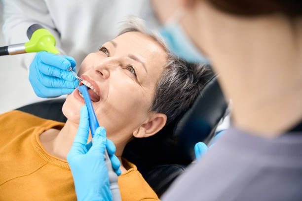istock Nurse holds saliva ejector while dentist engaging in professional tooth cleaning 2135833255