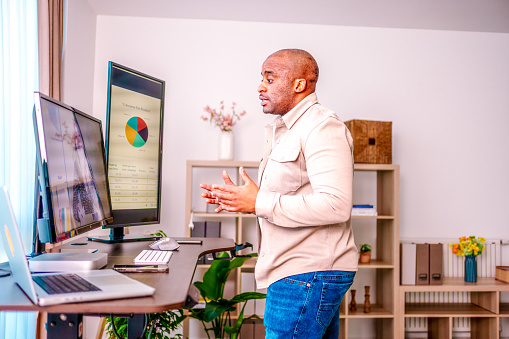 Black Man at Standing Desk Home Office Talking on Business Video Call