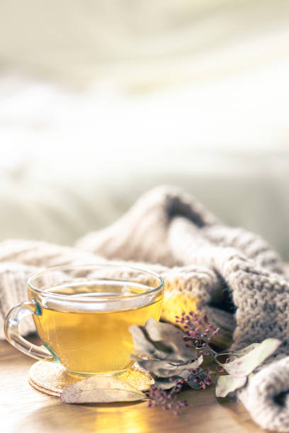 istock Glass cup with herbal tea and knitted element on a blurred background. 2135852954