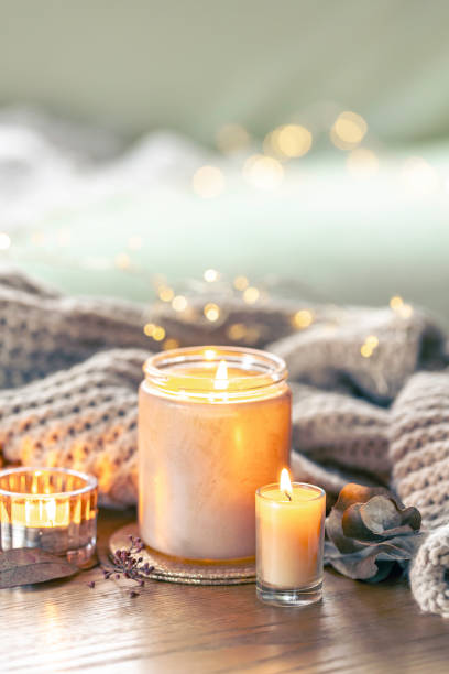 istock Cozy composition with candles and a knitted element on a blurred background. 2135852959