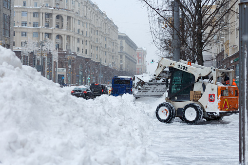 A lot of snow on Tverskaya Street and a small front-end loader. Moscow, Russia, February 13, 2021.