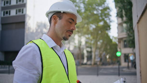 istock Focused contractor filling architectural documents street closeup. Man working 2135876867