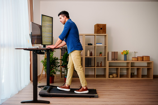 Man is  Working at Home Office and  Walking on Under Desk Treadmill