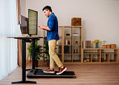 Man is  Working at Home Office and  Walking on Under Desk Treadmill