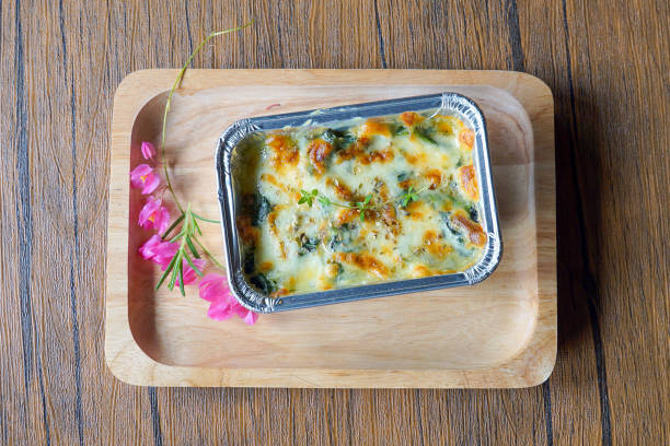 A close-up view of a freshly baked pasta casserole in a glass dish, featuring a golden, bubbling cheese crust. The dish is shown inside the oven, highlighting its crispy, appetizing top layer and creamy interior. Perfect for illustrating home cooking, comfort food, baking, or family meals.