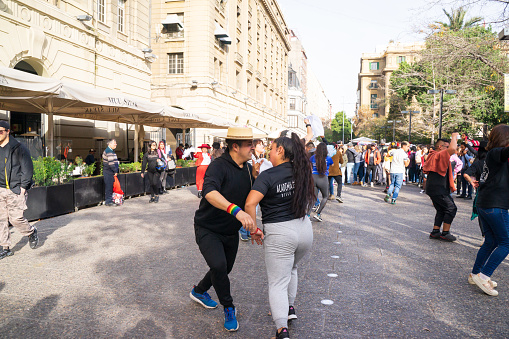 Groups of beautiful and happy Chilean people are dancing on the downtown Santiago. They laugh, share love, make beautiful latin dance. It is also a national folk dance named La Cueca on guitar music