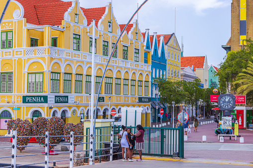 Willemstad. Curacao. 04.19.2024. Stunning vista of Willemstad's downtown area with vibrant houses, under a bright, cloudless sky, with people strolling along the streets.