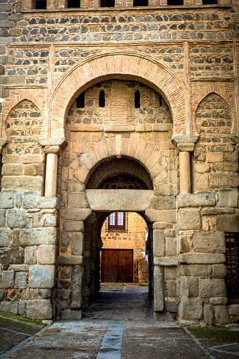 Vertical photo of the medieval entrance door of Alfondo VI, ancient Bisagra door in the wall of Toledo, Castilla la Mancha, Spain