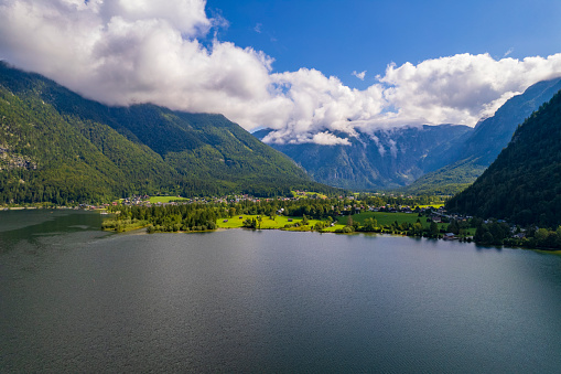 Aerial view of the lake, village, green fields and forest in mountains Alps Austria, travel and nature concept
