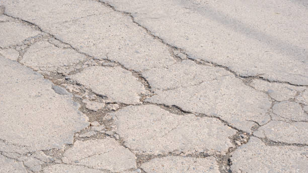 istock The old damaged concrete road background with broken and crack texture on surface 2135954540