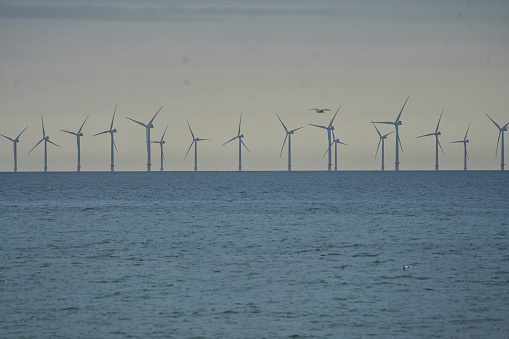 The wind turbines of the UK - Rampion Wind Farm in East Sussex, Brighton, England: Rampion is an offshore wind farm developed by E.ON, operated by RWE, off the Sussex coast in the UK. The wind farm has a capacity of 400 MW (originally 700 MW was planned). The wind farm was commissioned in April 2018 and was the first offshore wind farm for the whole south coast of England.\n\nSea in Brighton, England. The sea and sky sunset over the Atlantic Ocean (The Pond), Sea in Brighton, East Sussex England - The breathtaking scene of the sun setting over the Atlantic Ocean (The Pond), with the sea and sky blending their vibrant hues, captivated spectators on Brighton Beach in East Sussex, England, Europe. calmness in the city.