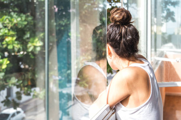 istock young woman looking out of window 2135991828