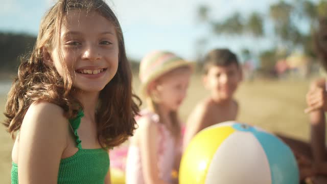 Portrait of a child girl playing with friends on the beach