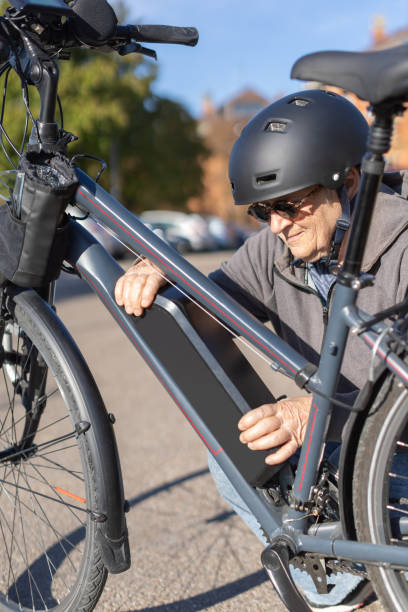 istock granny cyclist changing battery on e-bike 2136029591