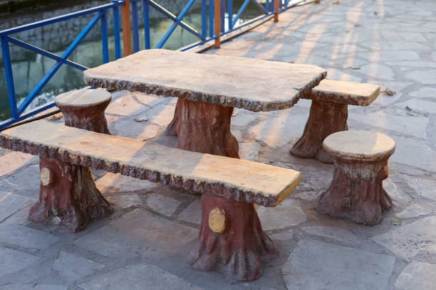 Stone table and stools set by a serene water body