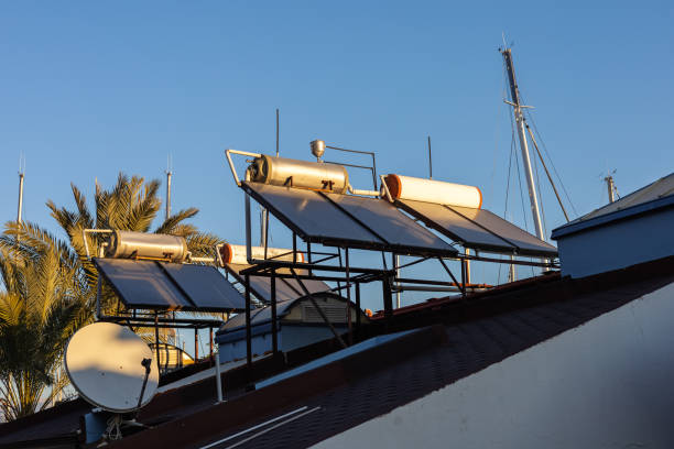 istock Eco-friendly solar panels and water heaters at sunset. 2136059700