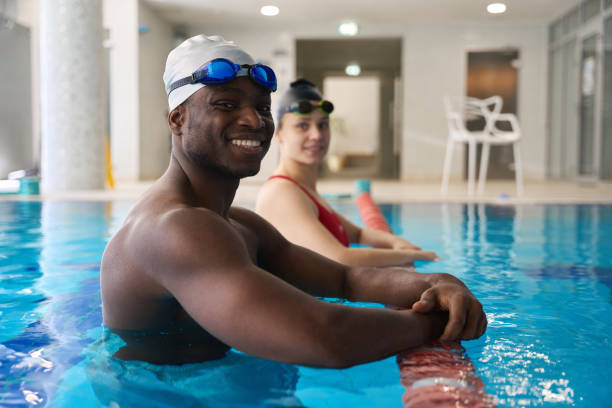 istock Young swimmers posing for camera in water 2136064641