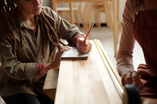 Young students in a coffee bar talking and looking in a notebook