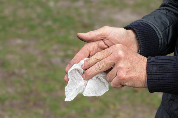 istock Man wiping his hands with a damp cloth after work.Dirty male hands. 2136138239