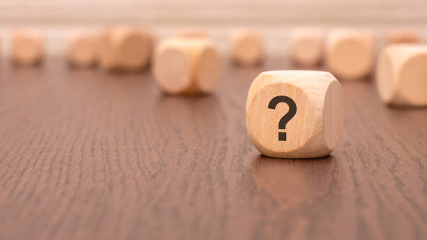 istock in the foreground is one wooden block with a question mark and a reflection from the table surface 2136161718
