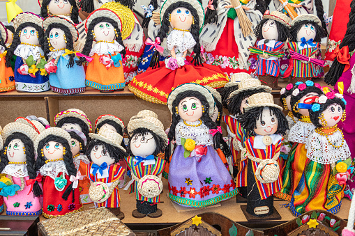 Handmade souvenir dolls in the traditional embroidered clothes, ponchos and straw hats of the city Cuenca and the province of Azuay. Ecuador. Souvenir market