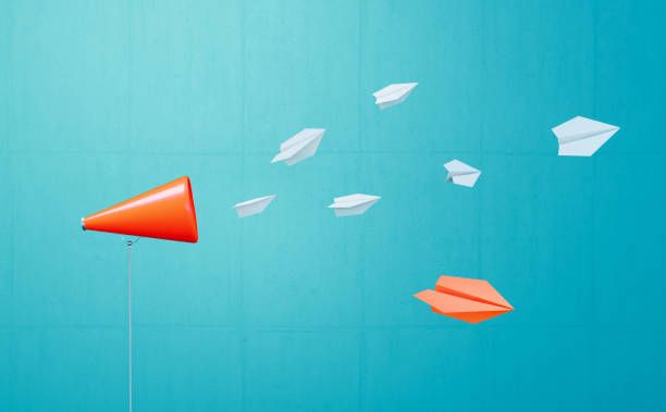 White Paper Planes Flying Away From A Coral Colored Megaphone Before Blue Background