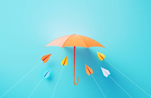 istock Paper Planes Flying Towards A Coral Colored Umbrella On Blue Background 2136186284