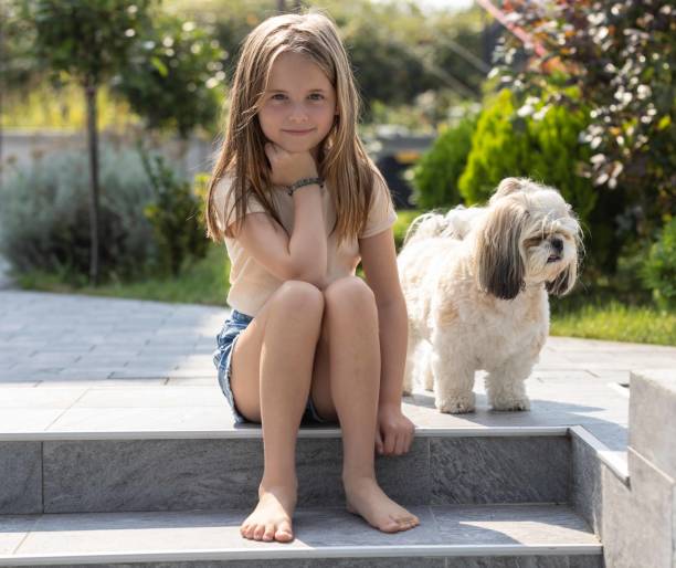 Young girl posing with a smile beside her dog